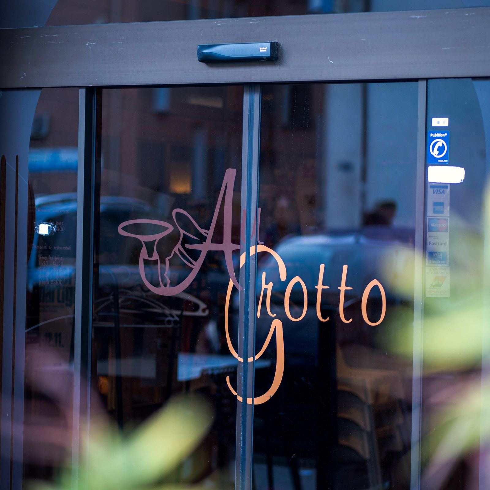 La porte vitrée du Grotto et son logo